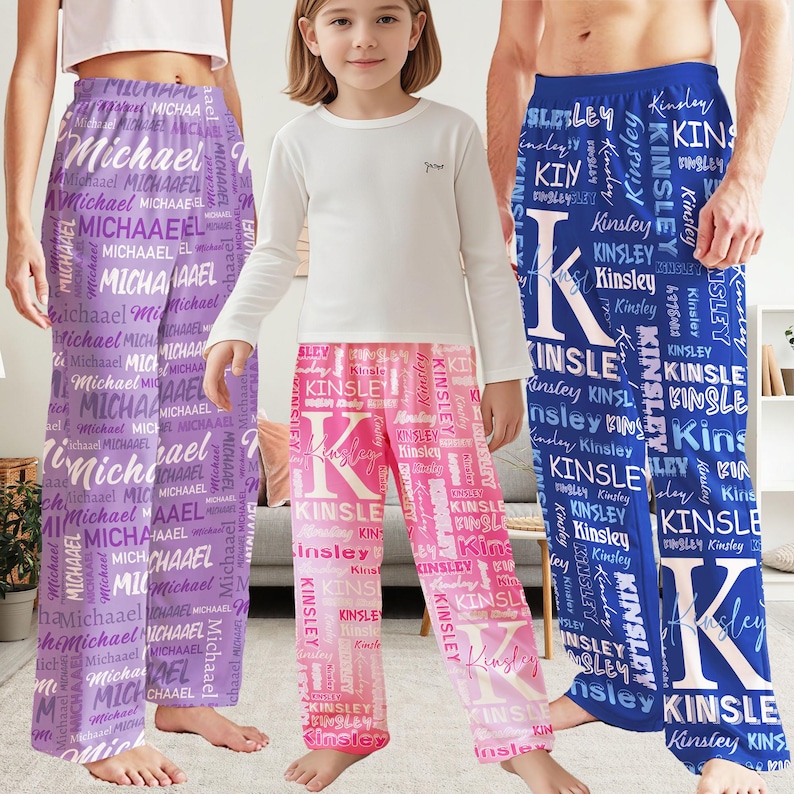 May include: Three pairs of personalized pajama pants in the image. One pair is purple with the name "Michael" repeated. Another is pink with "Kinsley". The third pair is blue with "Kinsley".