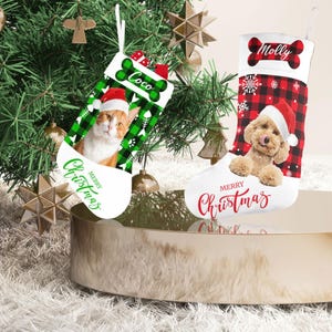May include: Two personalized Christmas stockings with a red and black buffalo plaid pattern. One stocking features a cat with the name "Coco" and the other features a dog with the name "Molly". Both stockings have the text "Merry Christmas" on them.
