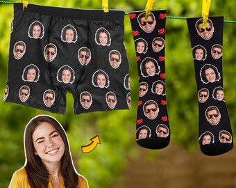 May include: Black boxer shorts with a repeating pattern of faces. Two pairs of black socks with a repeating pattern of faces and red hearts.