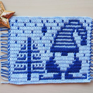 Pu&ograve; includere: Un sottopentola all'uncinetto fatto a mano, nei toni del blu e del bianco, con un motivo geometrico e bordi sfrangiati. Il sottopentola quadrato presenta un design dettagliato. &Egrave; un oggetto decorativo.