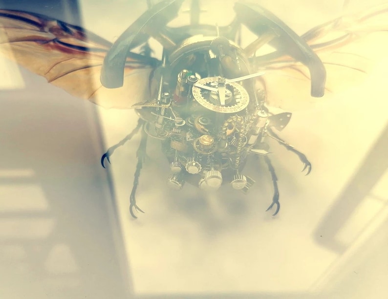 May include: A steampunk-style beetle sculpture made of metal gears and clock parts. The beetle has wings and legs, and its body is covered in intricate details.