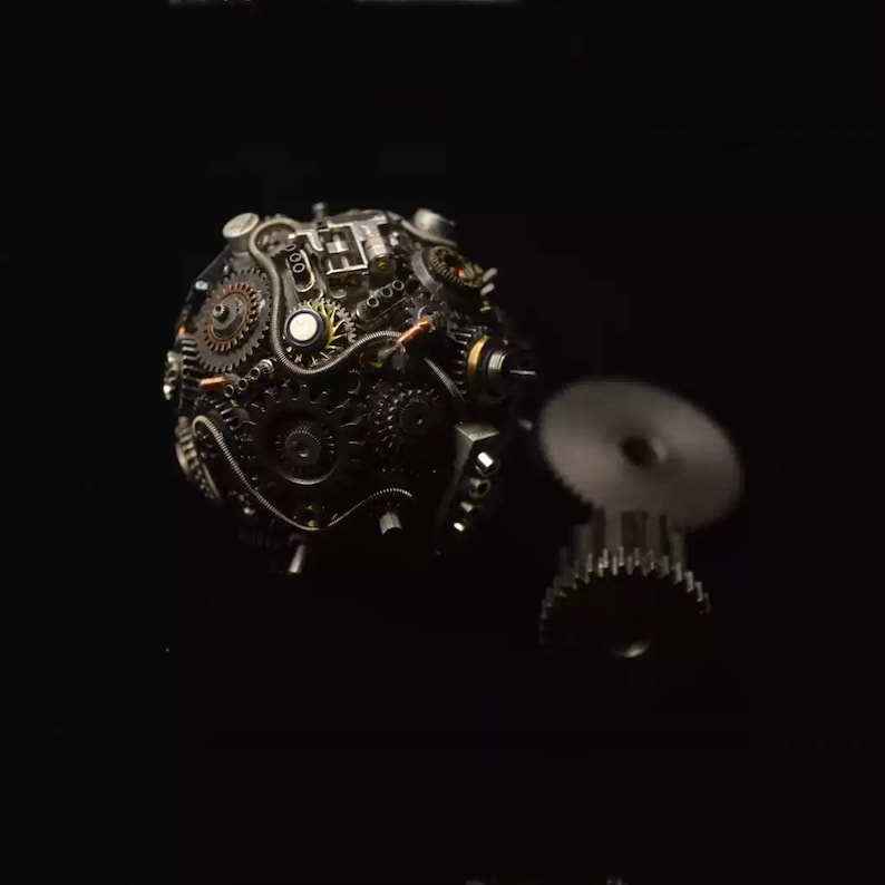 Pu&ograve; includere: Una scultura sferica in stile steampunk realizzata con ingranaggi e ruote dentate in metallo, con un ingranaggio pi&ugrave; piccolo attaccato al lato.