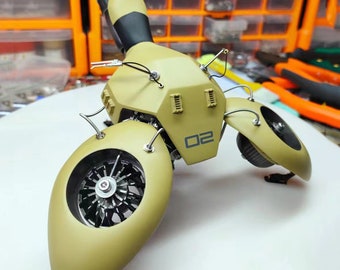 Puede incluir: Un modelo de motocicleta futurista de color verde caqui con un tubo de escape negro y una rueda plateada. La motocicleta tiene el número "02" impreso en la parte delantera.