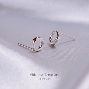 May include: A pair of silver circle stud earrings. The earrings are simple and elegant, and would make a great gift for any occasion.