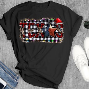 K&ouml;nnte beinhalten: Schwarzes T-Shirt mit einem rot-wei&szlig; karierten Design, einem blauen Stern mit roten und wei&szlig;en Streifen und dem Wort "TEXAS" in wei&szlig;en Buchstaben. Das Design ist von einem Leopardenmuster und bunten Lichtern umgeben.