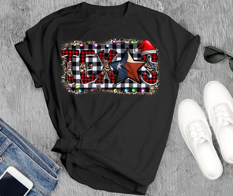 K&ouml;nnte beinhalten: Schwarzes T-Shirt mit einem rot-wei&szlig; karierten Design, einem blauen Stern mit roten und wei&szlig;en Streifen und dem Wort "TEXAS" in wei&szlig;en Buchstaben. Das Design ist von einem Leopardenmuster und bunten Lichtern umgeben.