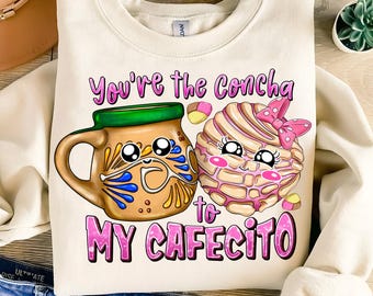 May include: A white sweatshirt with a pink and brown cartoon concha and a brown cartoon coffee mug with the text "You're the Concha to my Cafecito".