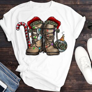 Puede incluir: Camiseta blanca con un dise&ntilde;o navide&ntilde;o con dos botas de camuflaje con luces, un bast&oacute;n de caramelo y una bola de Navidad.