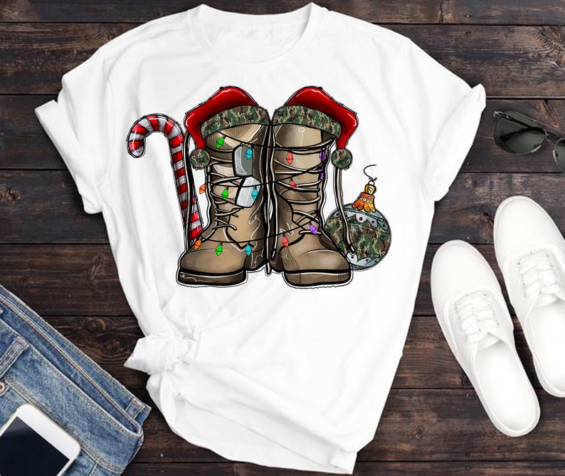 Puede incluir: Camiseta blanca con un dise&ntilde;o navide&ntilde;o con dos botas de camuflaje con luces, un bast&oacute;n de caramelo y una bola de Navidad.