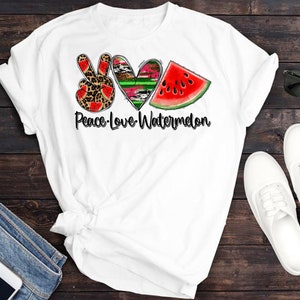 May include: White t-shirt with a peace sign, heart, and watermelon graphic. The text "Peace-Love-Watermelon" is printed below the graphic.