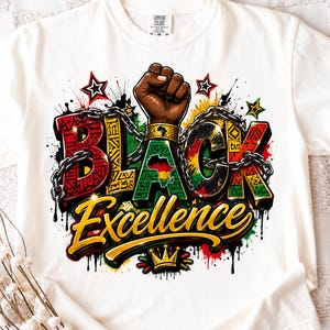 Op de afbeelding: Wit T-shirt met de tekst "BLACK Excellence" in een kleurrijk ontwerp. Het ontwerp bevat een vuist, kettingen, sterren en het Afrikaanse continent in groen, geel en rood. Het shirt heeft een ronde hals en korte mouwen.
