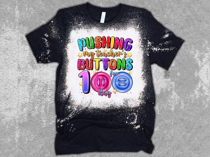K&ouml;nnte beinhalten: Ein schwarzes T-Shirt mit einem gebleichten Design, auf dem "Pushing my teacher's buttons for 100 days" mit bunten Kn&ouml;pfen und Sternen steht.