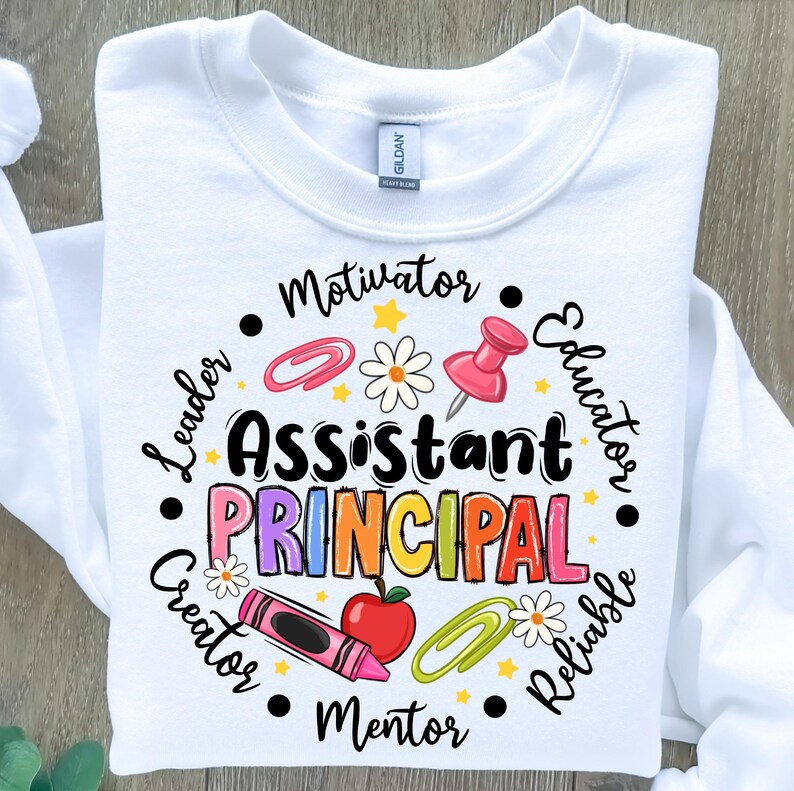 May include: White sweatshirt with the words "Assistant Principal" in colorful letters. The design includes a crayon, apple, paperclip, push pin, and daisy. Surrounding the words are the words "Leader, Motivator, Educator, Reliable, Creator, Mentor."