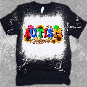 May include: A black t-shirt with a white bleach design. The design features the word "AUTISM" in colorful letters, a puzzle piece, sunflowers, and the words "Advocate".