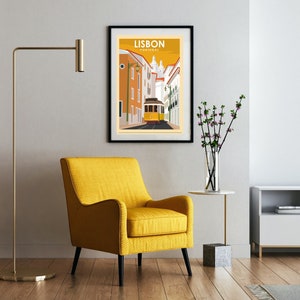 Puede incluir: Un sill&oacute;n amarillo con patas negras se encuentra en una sala de estar con un p&oacute;ster enmarcado de una escena callejera en Lisboa, Portugal. El p&oacute;ster dice "Lisboa, Portugal".