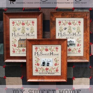 May include: Three framed cross-stitch embroidery designs with the text "My Sweet Home" and different dates and locations. The designs feature a house, a bird, and a tree.