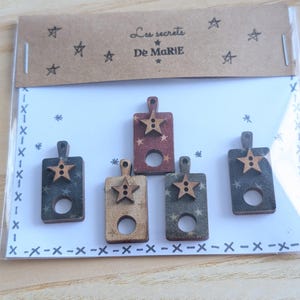 May include: Set of four wooden buttons with a star design. Each button is covered in fabric with a different pattern: red with white stars, blue with white stars, beige with brown stars, and blue with white stars. The buttons have a hole in the center and a brown wooden star on top.