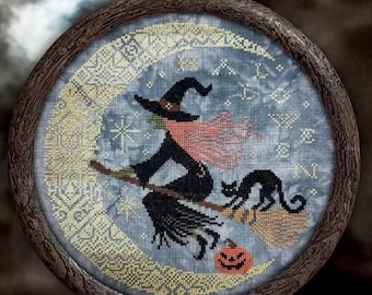 May include: A cross-stitch design in a wooden hoop features a witch on a broom with a black cat and a jack-o'-lantern. The witch wears a black hat and cloak, with a pink scarf. The background is a blue night sky with a crescent moon.