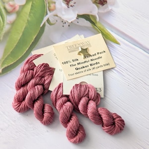 May include: Four skeins of 100% silk embroidery floss in a dusty rose colour. The floss is packaged in a small white card with the text "TREENWAY silks 100% Silk Thread Pack The Mindful Needle Quaker Birds Four skeins of silk (40 yards total) nd floss 10 ya 10 23".