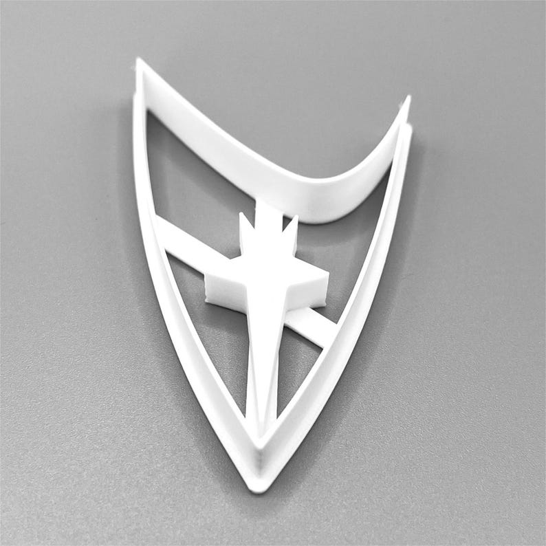 Puede incluir: Cortador de galletas de pl&aacute;stico blanco con forma del emblema de la Flota Estelar de Star Trek. El cortador presenta una estrella estilizada con una punta puntiaguda.