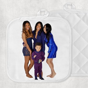 May include: White pot holder with a printed image of four people. The people are wearing blue and dark blue dresses and outfits. The pot holder has a loop for hanging and a quilted pattern on the back.