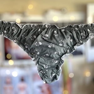 May include: Gray underwear with a white skull and crossbones pattern.