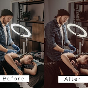 Puede incluir: Un tatuador con una camisa vaquera azul y una boina negra est&aacute; trabajando en el brazo de un cliente. El cliente est&aacute; tumbado en una mesa con una s&aacute;bana blanca. El tatuador est&aacute; usando una luz de anillo para iluminar el &aacute;rea de trabajo.