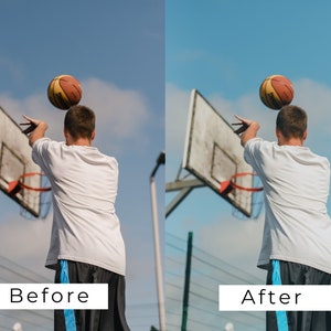 Op de afbeelding: Een persoon in een wit shirt en een zwarte broek speelt basketbal buiten. De persoon gooit de bal met zijn rechterhand in de lucht. De bal is oranje en bruin. De persoon staat voor een basketbalring.