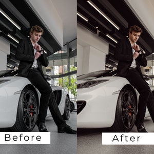 Op de afbeelding: Een man in een zwart pak en zwarte broek zit op de motorkap van een witte sportwagen. De auto staat in een showroom met een grijze vloer.