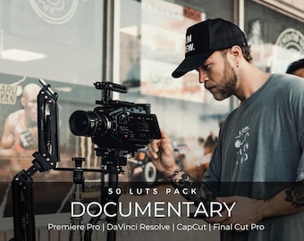 May include: A professional cinema camera mounted on a black articulated support arm. The camera features a lens, a side display screen, and various control buttons. Text overlay reads: 50 LUTS PACK DOCUMENTARY Premiere Pro | DaVinci Resolve | CapCut | Final Cut Pro.