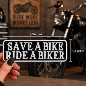 May include: A rectangular black sticker with white text that reads SAVE A BIKE RIDE A BIKER. The sticker measures 4.5 inches in width and 1.5 inches in height. It is labeled as water-resistant or waterproof, featuring a bold, high-contrast design.