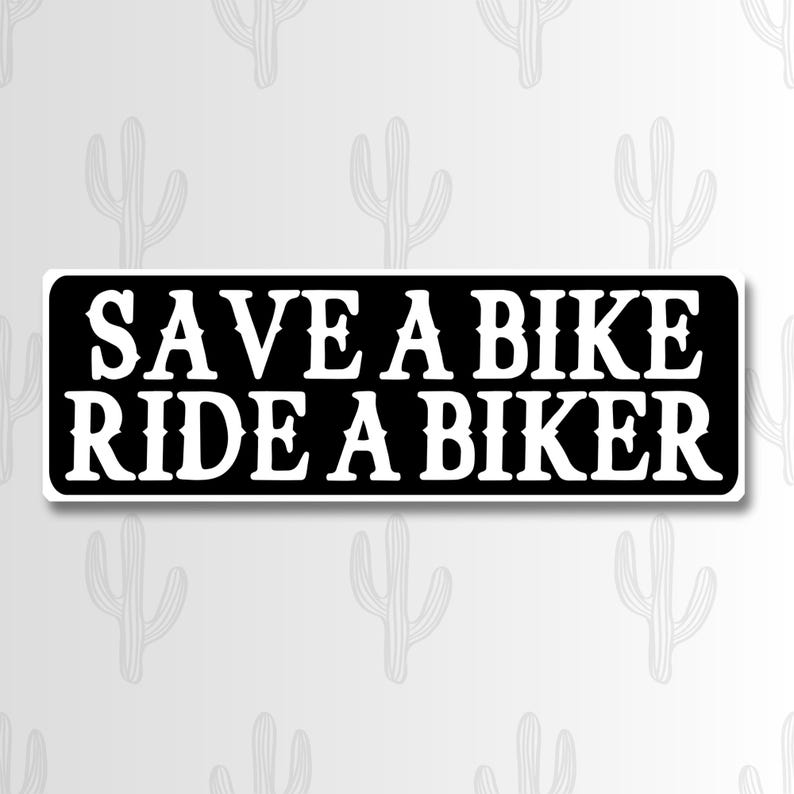 May include: A rectangular black sticker with rounded corners featuring white text that reads SAVE A BIKE RIDE A BIKER in a bold, serif font. The sticker has a clean, high-contrast design with the white lettering centered against the black background.
