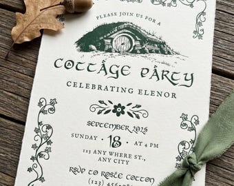 May include: A cream-colored invitation card with dark green ink featuring a drawing of a round-door cottage, ivy borders, and the text "Cottage Party Celebrating Elenor September 2025". It is decorated with a dried oak leaf and a green ribbon.