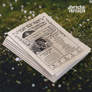 May include: A stack of wedding announcement cards with a vintage newspaper design. The headline reads "The Hobbiton Outpost" with a photo of a couple. The text includes "The Fellowship of the Rings" and "Hobbit-Hearted thank you". The cards are on a green surface.