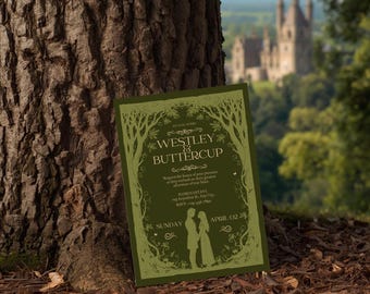 Puede incluir: Una invitación de boda verde con el texto "Westley & Buttercup" en una fuente decorativa, enmarcada por un diseño de árbol. La invitación está apoyada contra un tronco de árbol, con un castillo al fondo.