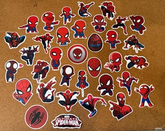 May include: A collection of Spider-Man stickers in various poses and designs. The stickers feature the iconic red and blue suit, with some showcasing the character's mask and logo. Includes a sticker with the text "Marvel Ultimate Spider-Man".
