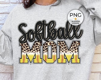 Op de afbeelding: Een grijs sweatshirt met de tekst "Softball Mom" in zwart met een luipaardprint en een geel softbalontwerp.