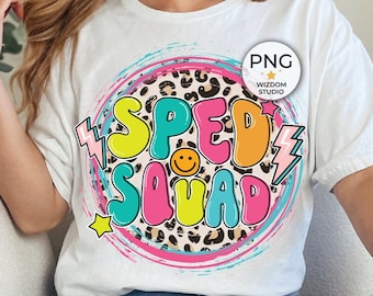 Pode incluir: Camiseta branca com um gráfico colorido "SPED SQUAD". O design apresenta um círculo com estampa de leopardo, raios, um smiley e estrelas. A camisa é usada com jeans desbotados.