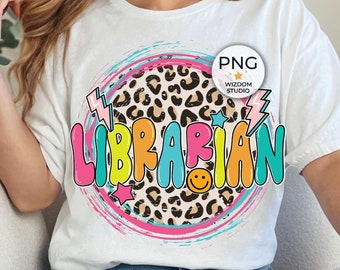 May include: A white t-shirt with a colorful graphic design that says "LIBRARIAN" with a leopard print and a smiley face. The design is surrounded by a pink, blue, and yellow swirl.