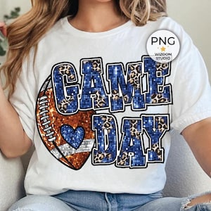 Peut inclure: Un t-shirt blanc avec un motif de ballon de football bleu et marron et le texte "GAME DAY" en lettres bleues pailletées avec un motif léopard.