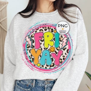 May include: A gray sweatshirt with a colorful graphic design that says "FRIYAY" in a circle with a leopard print background. The graphic also includes a lightning bolt, a star, and a smiley face.