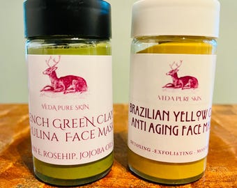 Może przedstawiać: Dwa szklane słoiki z białymi etykietami i czarnymi pokrywkami. Etykiety mają logo jelenia i tekst "VEDA PURE SKIN". Słoik po lewej stronie zawiera zieloną glinianą maskę do twarzy i tekst "French Green Clay Pulina Face Mask" i "With Rosehip, Jojoba Oil". Słoik po prawej stronie zawiera żółtą glinianą maskę do twarzy i tekst "Brazilian Yellow Clay Anti Aging Face Mask" i "Detoxing - Exfoliating - Moisturizing".