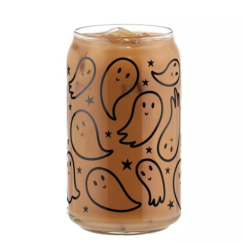 May include: A glass can with a brown liquid inside. The can has a black and white pattern of ghosts and stars.