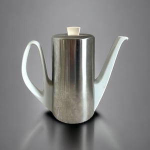May include: A silver teapot with a white porcelain spout and handle. The teapot has a white plastic lid.
