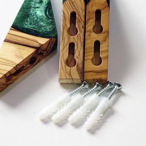 May include: Two wooden wall mounts with green epoxy resin inserts and four white plastic drywall anchors and screws.