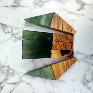 May include: Four green and brown resin and wood bookends. The bookends are shaped like triangles with a green resin top and a brown wood base.