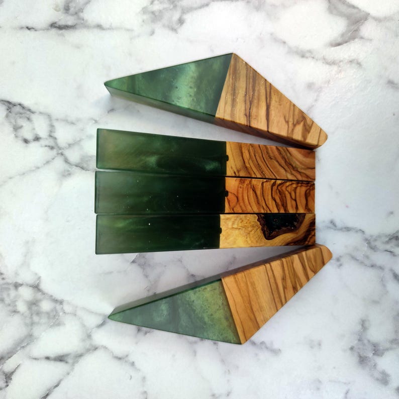 May include: Four green and brown resin and wood bookends. The bookends are shaped like triangles with a green resin top and a brown wood base.