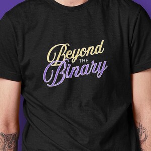 Op de afbeelding: Een zwart t-shirt met korte mouwen en de tekst Beyond The Binary in een gestileerd geel en paars lettertype op de borst. Het shirt heeft een ronde hals en is gemaakt van een effen zwarte stof met een gladde en gelijkmatige textuur.