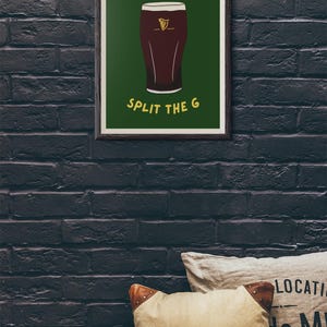 May include: A framed print with a green background and a cartoon illustration of a pint of Guinness. The text "SPLIT THE G" is printed in yellow below the pint.