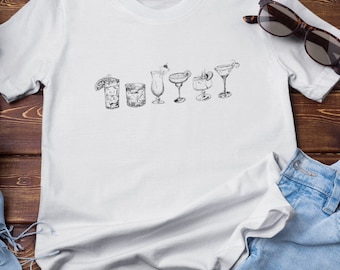 May include: White t-shirt featuring a line of six different types of cocktail glasses drawn in black ink.